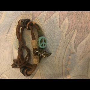 Brown bracelet with leaf charm and peace sign